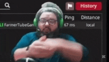 a man wearing headphones and glasses is giving a thumbs up .