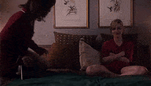 a man is kneeling on a bed next to a woman .