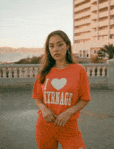 a woman wearing a red t-shirt that says i love nyrnage