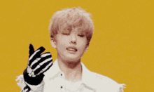 a young man with pink hair is wearing skeleton gloves and making a peace sign