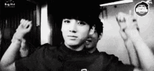 a black and white photo of a young man in a black shirt .