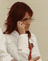 a woman with red hair is wearing a white shirt and tie