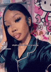 a girl is taking a selfie with a hello kitty wall in the background .