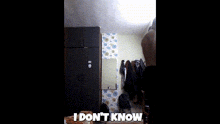 a shirtless man is standing in a room with a sign that says `` i don 't know ''