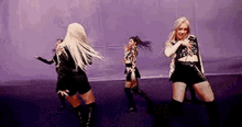a group of women are dancing on a stage in a room .