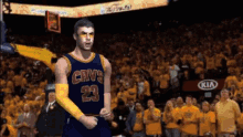 a basketball player wearing a cavs jersey stands in front of a crowd