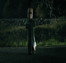 a car is driving down a road at night with a person flying in the air