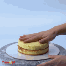 a cake is being stacked on top of another cake on a plate that says yum up on it