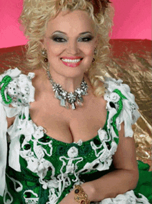 a woman in a green and white dress is smiling and wearing a bracelet