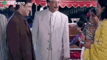 a man in a suit and tie is talking to a woman in a yellow dress .