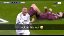 a soccer player is celebrating a goal while another player is laying on the ground