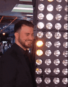 a man standing in front of a wall of lights