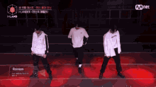a group of men are dancing in front of a mnet sign