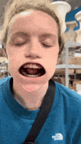 a woman wearing a blue north face sweatshirt with her mouth open