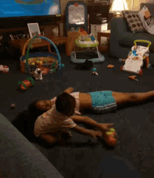 two children laying on the floor in a living room with toys