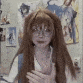 a girl wearing glasses and a wig is standing in front of a wall with anime posters .