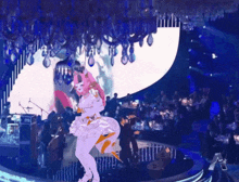 a woman in a white dress is dancing in front of a crowd