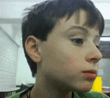 a close up of a young boy 's face with his eyes closed