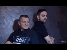 two men are standing next to each other and hugging each other .
