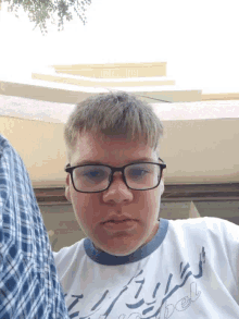 a young man wearing glasses and a shirt that says ' abercrombie ' on it
