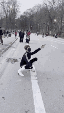 a woman is squatting down on the side of the road while wearing high heels