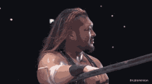 a man with long red hair is holding a wrestling ring with the hashtag #njdominion