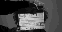 a person holding a clapper board that says how to vince martell greg s. reich