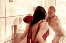 a woman in a red dress stands next to a woman in a white dress