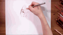 a person is drawing a face with colored pencils