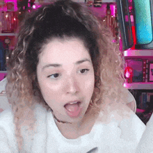 a girl with curly hair is making a funny face