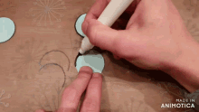 a person is drawing circles on a piece of paper with a marker and the words made in animotica on the bottom right