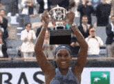 a woman holds up a trophy in front of an bnp logo