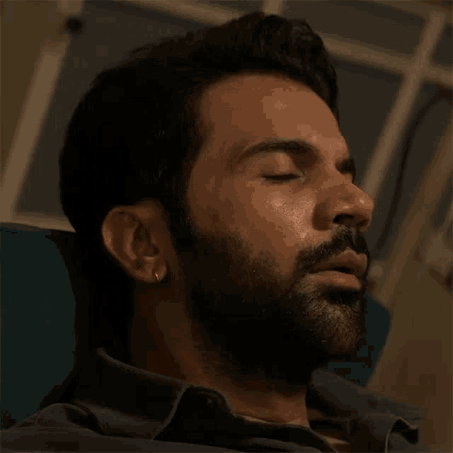 a man with a beard is sitting in a chair and looking up
