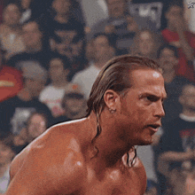 a man without a shirt is standing in front of a crowd with a star on the bottom right