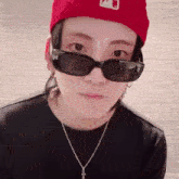 a close up of a person wearing sunglasses and a red hat