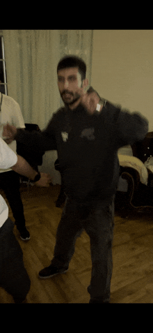 a man with a beard wearing a black sweatshirt with a white eagle on it