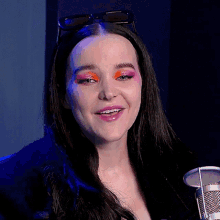 a close up of a woman wearing sunglasses and bright makeup