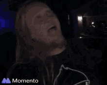 a man with long hair and a beard is making a funny face with the word momento behind him
