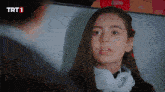 a girl with headphones around her neck looks at the camera with trt1 written on the bottom