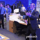a man in a suit and tie stands in an office with peacock written on the bottom