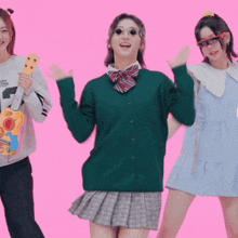 a girl wearing a green cardigan and a plaid skirt stands next to two other girls