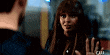 a woman with a fringe is talking to a man with a cw logo in the corner