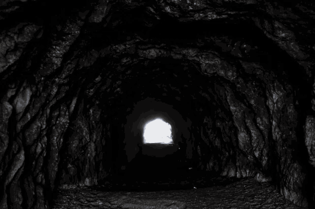 a light shines through a hole in a cave