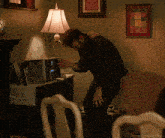 a man standing in a living room next to a lamp and a picture that says daredevil shots