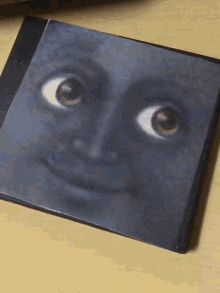 a picture of a face with big eyes on a table