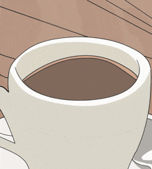 a cup of coffee is sitting on a saucer on a wooden table