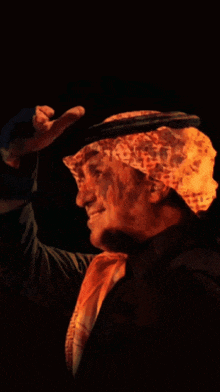a man wearing a leopard print head scarf and a hat