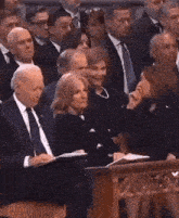 a group of people are sitting in a row in a room .