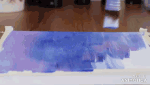 a blue and purple painting is being made in an animated video