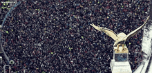 a statue of an eagle is sitting on top of a trophy in front of a crowd of people with the words lewannacia below
